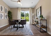 Thumbnail 8 of 18 - A dining room with a table and chairs.