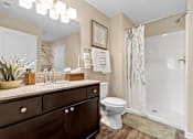 Thumbnail 14 of 18 - A bathroom with a toilet, sink, and shower.