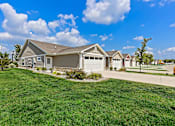 Thumbnail 1 of 18 - A house with a garage and a driveway in front of it.