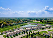 Thumbnail 7 of 18 - A bird's eye view of a residential area with houses and a lake.