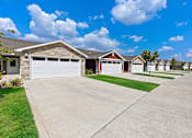 Thumbnail 2 of 18 - A row of houses with garages in front.