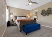 Thumbnail 13 of 18 - A bedroom with a bed, nightstand, and a ceiling fan.