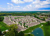 Thumbnail 6 of 20 - A bird's eye view of a residential area with houses, a lake, and a road.