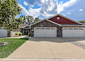 Thumbnail 1 of 20 - A red barn-style house with a white garage door.