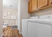 Thumbnail 14 of 20 - A white washing machine and dryer in a laundry room.