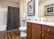 Thumbnail 17 of 20 - A bathroom with a toilet, a sink, and a shower curtain.