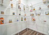 Thumbnail 9 of 20 - A pantry with white shelves and containers of food.