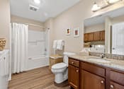 Thumbnail 18 of 20 - A bathroom with a toilet, sink, and bathtub.