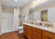 Thumbnail 13 of 19 - A bathroom with a toilet, sink, and shower.