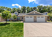 Thumbnail 1 of 19 - A large house with a driveway in front.