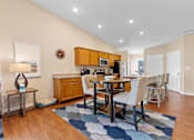 Thumbnail 6 of 19 - A modern kitchen with a dining table and chairs.