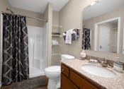 Thumbnail 13 of 19 - A bathroom with a toilet, sink, and shower curtain.