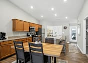 Thumbnail 6 of 19 - A kitchen with a table and chairs in the foreground.