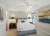 Thumbnail 12 of 19 - A bedroom with a large bed and a ceiling fan.