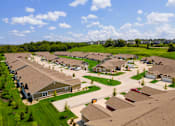 Thumbnail 19 of 19 - A suburban neighborhood with houses and green lawns.