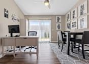 Thumbnail 15 of 19 - A room with a desk, chairs, and pictures on the wall.