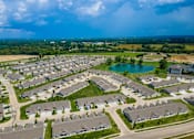 Thumbnail 9 of 19 - A bird's eye view of a residential area with houses, roads, and a lake.