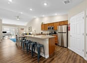 Thumbnail 5 of 19 - A kitchen with a bar area and a refrigerator.