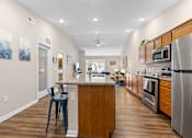 Thumbnail 4 of 19 - A kitchen with a wooden island and stainless steel appliances.