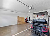 Thumbnail 11 of 19 - A room with a red vehicle and boxes in the background.