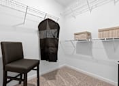 Thumbnail 8 of 19 - A chair sits in a room with a hanging chair and shelves.