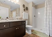 Thumbnail 18 of 19 - A bathroom with a toilet, sink, and shower.