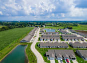 Thumbnail 17 of 19 - A bird's eye view of a residential area with houses and a river.