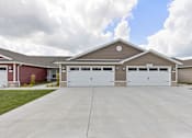Thumbnail 1 of 19 - A two-car garage with a brown roof and white doors.