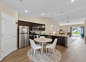 Thumbnail 13 of 19 - A modern kitchen with a dining table and chairs.