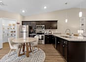 Thumbnail 3 of 19 - A modern kitchen with a table and chairs.