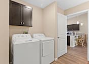 Thumbnail 11 of 19 - A laundry room with a washer and dryer.