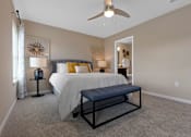 Thumbnail 14 of 19 - A bedroom with a bed, a bench, and a ceiling fan.