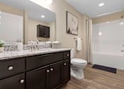 Thumbnail 19 of 19 - A bathroom with a white toilet and a black cabinet.