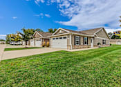 Thumbnail 1 of 19 - A house with a garage and a driveway in front.