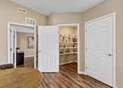 Thumbnail 6 of 19 - A room with a brown table and a white door.