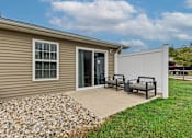 Thumbnail 18 of 19 - A house with a patio and a white fence.