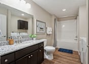 Thumbnail 15 of 19 - A bathroom with a white toilet, sink, and bathtub.