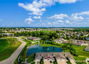 Thumbnail 10 of 19 - A suburban neighborhood with a pond and houses.