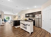 Thumbnail 4 of 19 - A modern kitchen with dark brown cabinets and white appliances.