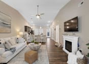 Thumbnail 9 of 19 - A living room with a white couch and a fireplace.