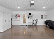 Thumbnail 15 of 19 - A room with a white ceiling and a black object on the floor.