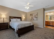 Thumbnail 14 of 19 - A bedroom with a bed, nightstands, and a ceiling fan.