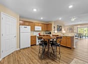 Thumbnail 5 of 20 - A kitchen with a table and chairs in the middle of the room.