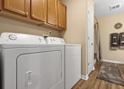 Thumbnail 12 of 20 - A laundry room with a washer and dryer.