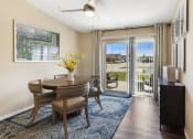 Thumbnail 7 of 10 - a dining room with a table and chairs and a sliding glass door