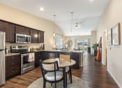 Thumbnail 2 of 10 - an open kitchen and dining area with a table and chairs