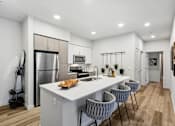 Thumbnail 18 of 33 - an open kitchen with a large island with four chairs