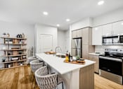 Thumbnail 19 of 33 - a kitchen with a large island and a stove and a refrigerator