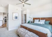 Thumbnail 17 of 25 - A bedroom with a large bed and a ceiling fan.