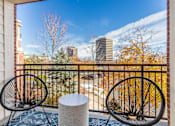 Thumbnail 25 of 25 - Two black chairs are placed on a balcony with a view of the city.